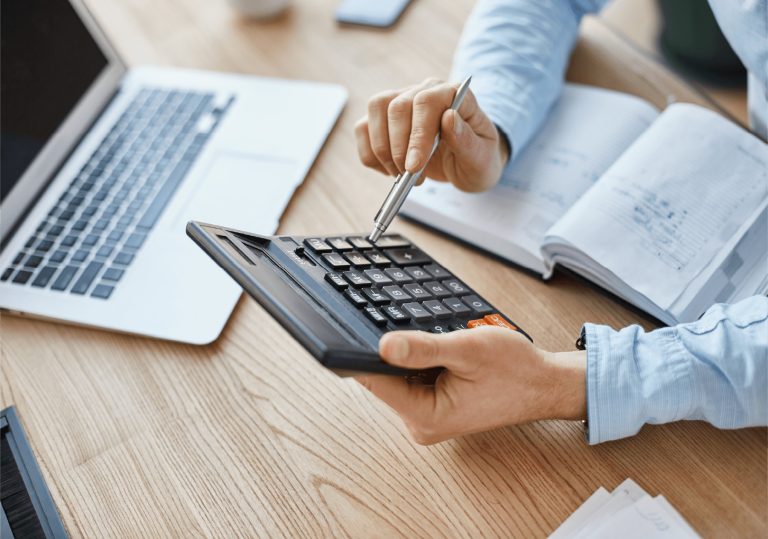 man at desk using a calculator